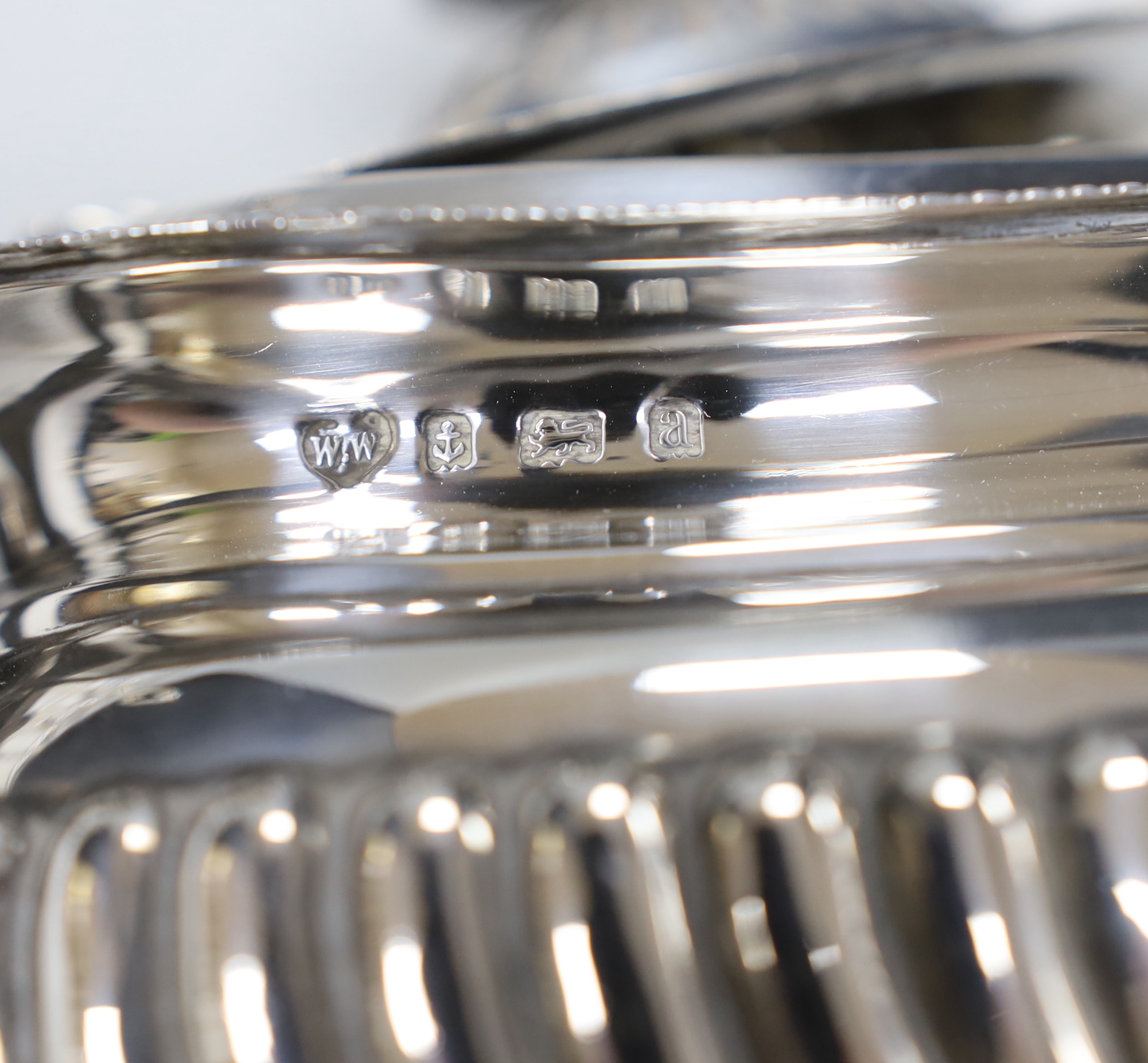 A late Victorian demi-fluted silver three piece tea set, Birmingham, 1899/1900 and a later small silver toastrack, gross weight 24.1oz.